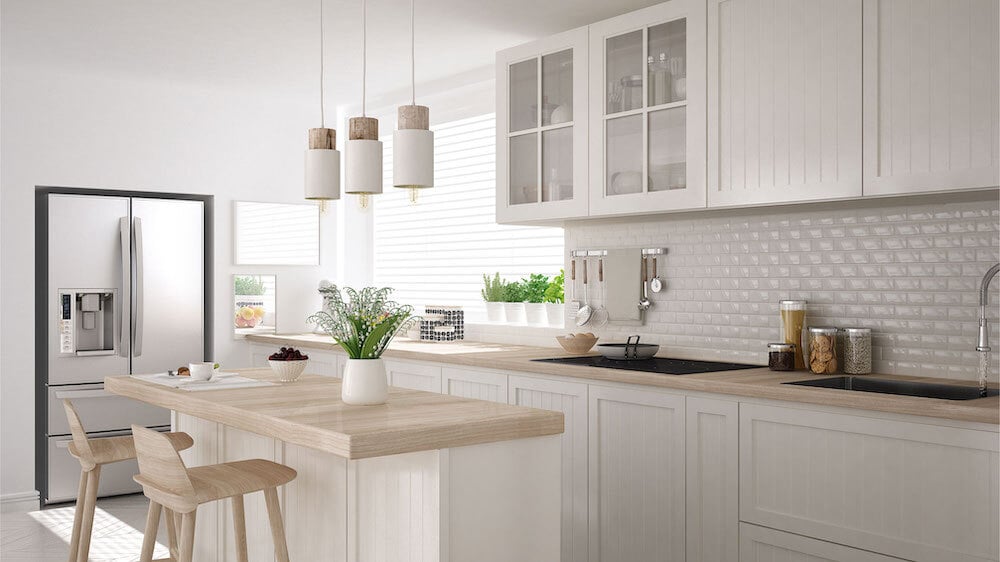shutterstock_1492614968 A clean white kitchen with light wood countertops